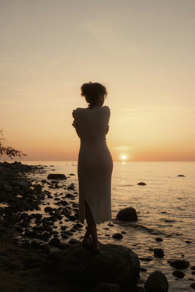 Woman hugging herself while watching the sun rise